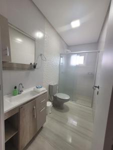 y baño con aseo, lavabo y ducha. en Apartamento Residencial Villa di Vienna en Nova Petrópolis