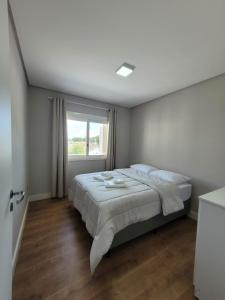 a bedroom with a large bed and a window at Apartamento Residencial Villa di Vienna in Nova Petrópolis