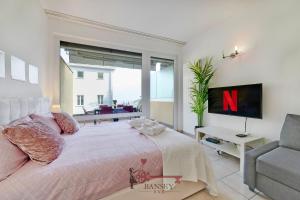 1 dormitorio con 1 cama, TV y sofá en 'Cuore di Rose' Parking - Welcome Set, Netflix, for 4 Persons -By EasyLife Swiss, en Breganzona
