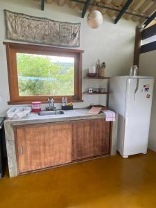 a kitchen with a white refrigerator and a window at Vila Chappada in Alto Paraíso de Goiás
