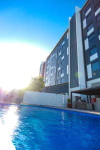 a large swimming pool in front of a building at Ibis Mackay in Mackay