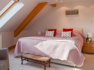 a bedroom with a bed with a pink comforter at The Roundel in Leuchars