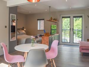 Cette chambre comprend deux lits, une table et des chaises. dans l'établissement Willows View, à Etchingham