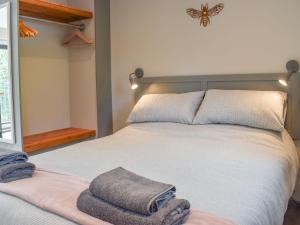 a bedroom with a bed with two towels on it at Willows View in Etchingham