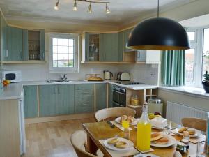 a kitchen with green cabinets and a table with food on it at New Trend in Chapel Saint Leonards