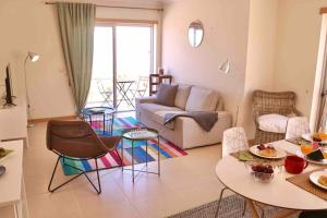 ein Wohnzimmer mit einem Sofa, einem Tisch und Stühlen in der Unterkunft Ocean Terrace - Private Patio with BBQ & Sea view in Nazaré
