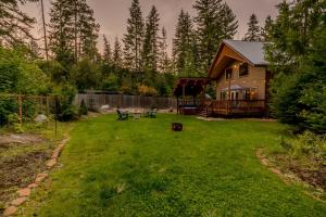 a yard with a wooden house with a fence at Paws in the Mountains by NW Comfy Cabins in Leavenworth