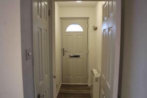 a hallway with a white door and a window at Modern studio apartment with parking in Chatham