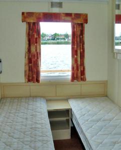 JabelにあるHouse Boat Jabelのベッド2台と窓が備わる客室です。