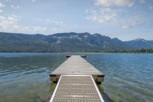 a dock on a lake with mountains in the background at Lazy Bear Lodge by NW Comfy Cabins in Leavenworth