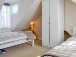 sypialnia z 2 łóżkami i białą szafką w obiekcie Courtyard Cottage w mieście Framlingham