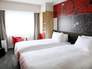 a hotel room with two beds and a window at ibis Osaka Umeda in Osaka