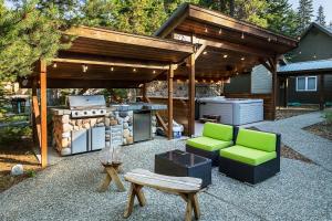 a patio with a grill and chairs and a barbecuepect at Riffle River Lodge by NW Comfy Cabins in Leavenworth