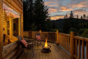 a deck with two chairs and a fire pit on a house at Bearfoot Chalet by NW Comfy Cabins in Leavenworth