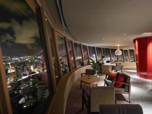 a restaurant with a view of a city at night at Novotel Okinawa Naha in Naha