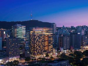 ein beleuchtetes Gebäude in einer Stadt in der Nacht in der Unterkunft Novotel Ambassador Seoul Dongdaemun Hotels & Residences in Seoul
