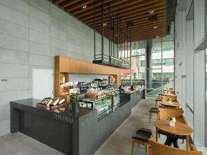 a restaurant with a counter and tables and chairs at Novotel Ambassador Seoul Dongdaemun Hotels & Residences in Seoul
