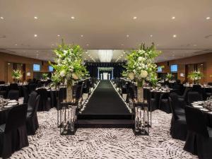 a banquet hall with a long aisle with tables and chairs at Novotel Ambassador Seoul Dongdaemun Hotels & Residences in Seoul