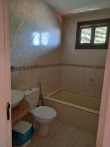 a bathroom with a toilet and a bath tub at Casa Solaris in Aquiraz