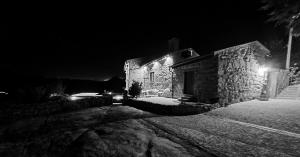a black and white photo of a stone building at night at Quinta da Abadia in Mangualde