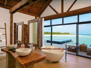 a bathroom with two sinks and a large window at Mӧvenpick Resort Kuredhivaru Maldives in Manadhoo