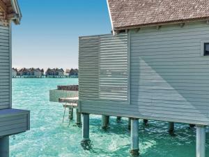 a house on a dock in the water at Mӧvenpick Resort Kuredhivaru Maldives in Manadhoo