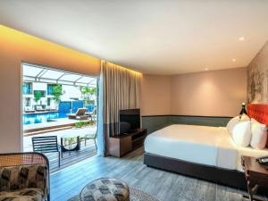 ein Hotelzimmer mit Bett und Balkon in der Unterkunft Mercure Langkawi Pantai Cenang in Pantai Cenang