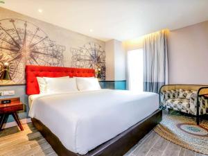 Schlafzimmer mit einem großen weißen Bett mit einem roten Kopfteil in der Unterkunft Mercure Langkawi Pantai Cenang in Pantai Cenang + 37 Fotos