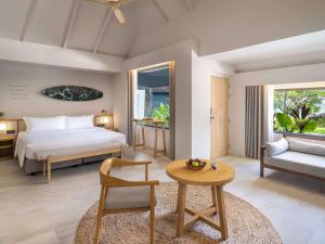 a bedroom with a bed and a table and a couch at Mercure Rayong Lomtalay Villas & Resort in Mae Pim