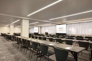 a conference room with tables and chairs and a screen at The Royal Sonesta Minneapolis Downtown in Minneapolis