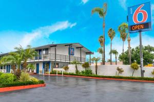 a building with a open sign in a parking lot at Motel 6-El Monte, CA - Los Angeles in El Monte