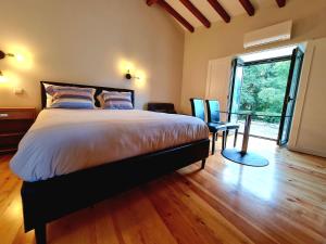 een slaapkamer met een groot bed en een groot raam bij Quinta da Abadia in Mangualde