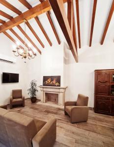 a living room with a fireplace and a couch and chairs at Quinta da Abadia in Mangualde