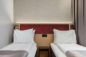 two beds sitting next to each other in a room at Bergen Harbour Hotel, WorldHotels Crafted in Bergen
