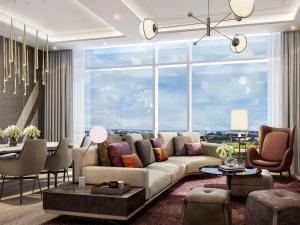 a living room with a couch and a large window at Swissôtel Clark Philippines in Clark