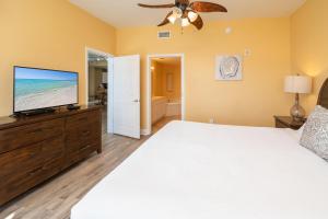 a bedroom with a bed and a flat screen tv at Tidewater2808 in Panama City Beach