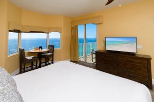 a bedroom with a bed and a television and a table at Tidewater2808 in Panama City Beach