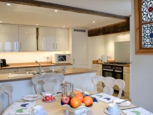 a kitchen with a table with a bowl of fruit on it at The Coach House in Chulmleigh