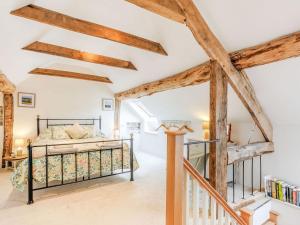 a bedroom with a bed in a room with wooden beams at The Old Milking Parlour in Wentnor