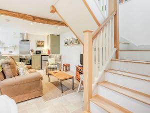 a living room with stairs leading to a kitchen at The Old Milking Parlour in Wentnor