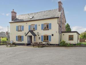 a large white building with blue windows and picnic tables at Lamb Inn in Stoke Prior