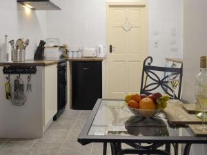 a kitchen with a table with a bowl of fruit on it at The Snug in Amlwch