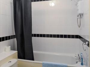 a bathroom with a bath tub and a toilet at The Snug in Amlwch