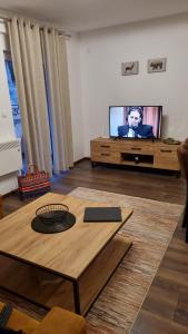 ein Wohnzimmer mit einem Couchtisch und einem TV in der Unterkunft Zlatar Holidays Apartmani in Nova Varoš