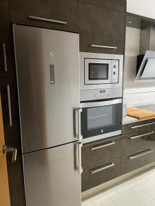 cocina con nevera de acero inoxidable y microondas en Apartamento Ubuntu, en Los Llanos de Aridane