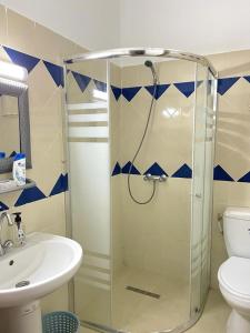 een badkamer met een douche, een toilet en een wastafel bij Soltane Résidence in Hammamet