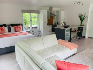 ギズボーンにあるLa Frontiere Boutique Accommodationのリビングルーム(白いソファ、ベッド付)