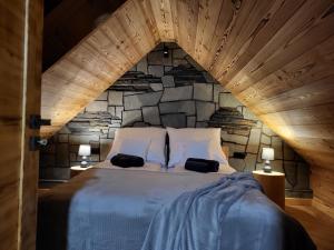 a bedroom with a large bed with a stone wall at Apartamenty Stylo in Istebna