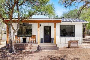 a small house with a porch and a tree at Casita 5 minutes from Gruene Hall and King Bed! in New Braunfels