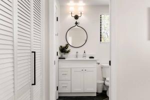 a white bathroom with a sink and a mirror at Casita 5 minutes from Gruene Hall and King Bed! in New Braunfels +12 photos